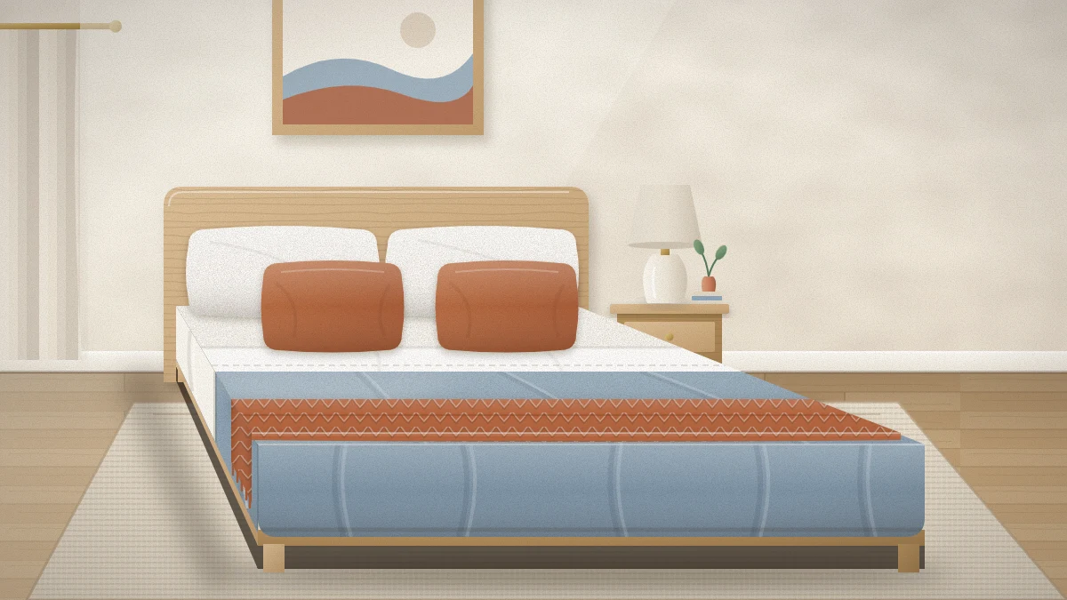 A neatly made bed with white sheets folded over a dusty blue duvet, two white pillows, two rust linen cushions and a rust knitted throw