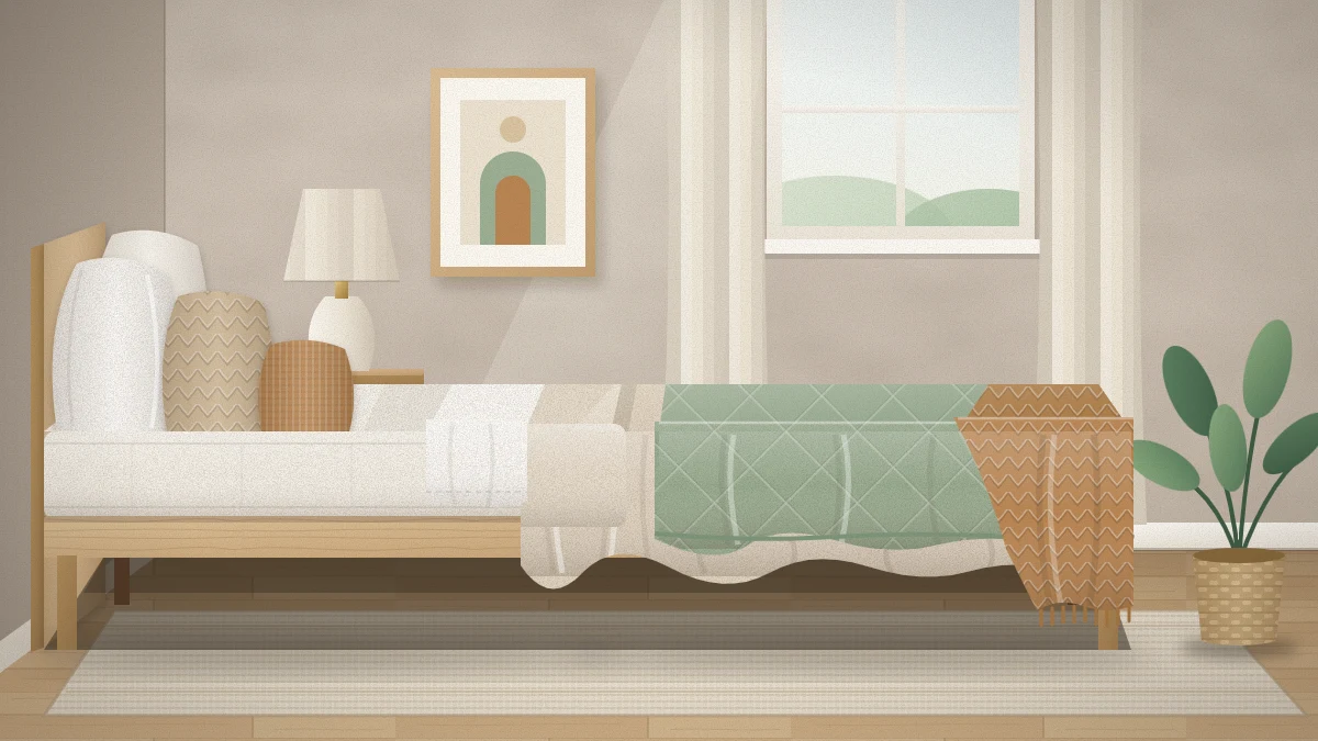 Side view of a layered bed with a white sheet folded over an oatmeal linen duvet, a quilted sage coverlet, a caramel knit throw and four pillows